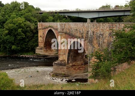 Pont en pierre, Drygrange Old Bridge, River Tweed, avec le pont moderne à poutres caissonnées en acier en arrière-plan, Melrose, Scottish Borders, Scotland, UK Banque D'Images