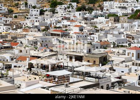 Lindos, Rodes, Grèce - Mai 2022: Vue aérienne des restaurants et autres bâtiments blanchis à la chaux dans la ville de Lindos Banque D'Images