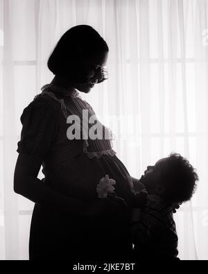 1970S ANONYME SILHOUETÉ FEMME ENCEINTE AFRO-AMÉRICAINE MÈRE ET SON JEUNE FILS PAR UNE FENÊTRE - J14162 HAR001 HARS FEMMES STUDIO TOURNÉ MAISON VIE COPIE ESPACE DEMI-LONGUEUR FEMMES HOMMES SILHOUETTES B&W CONTOUR ENCEINTE MÈRE SILHOUETTED AFRO-AMÉRICAINS AFRO-AMÉRICAIN ET EXPECTANT EXPECTANT MÈRE NOIR ETHNICITÉ MATERNITÉ MATERNITÉ ANONYME ATTENDRE JEUNES MÈRES JEUNE FEMME ADULTE NOIR ET BLANC HAR001 AFRO-AMÉRICAINS À L'ANCIENNE Banque D'Images