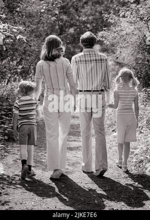 1970S FAMILLE DE QUATRE DE DERRIÈRE EN JETANT UNE OMBRE MARCHANT SUR UN CHEMIN BOISÉ TENANT LES MAINS - J14169 HAR001 HARS VERS LE BAS MARI DAD QUATRE MAMAN D'EXERCICE OMBRE VÊTEMENTS NOSTALGIQUE ACTIVE PAIRE 4 MÈRES VIEUX TEMPS NOSTALGIE VIEILLE MODE SOEUR 1 FORME PHYSIQUE STYLE JUVÉNILE SAIN VACANCES ENFANTS FAMILLES JOIE STYLE DE VIE CÉLÉBRATION FEMMES MARIÉES RURAL CONJOINT MARI NATURE COPIE ESPACE FEMMES FILLES PERSONNES SOINS HOMMES SÉRÉNITÉ SŒURS PÈRES B&W PARTENAIRE ÉTÉ TEMPS HORS ACTIVITÉ CHEMIN BONHEUR PHYSIQUE AVENTURE FORCE VOYAGE ESCAPADE DADS LOISIRS TENIR LES MAINS VUE ARRIÈRE VACANCES Banque D'Images