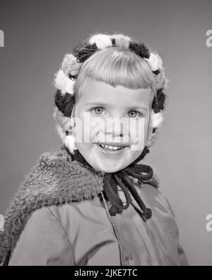 1960S PORTRAIT SOURIRE BLONDE FILLE REGARDANT L'APPAREIL PHOTO PORTANT HIVER LAINE TRICOT CHAPEAU ÉCHARPE ET VESTE PRÊTE POUR LE FROID - J255 HAR001 HARS COPIE ESPACE CONFIANCE B&W TRICOTÉ HIVER OEIL CONTACT BONHEUR GAI ET SOURIRES JOYEUX HIVERNAL ÉLÉGANT CROISSANCE JUVÉNILES SAISON BANGS NOIR ET BLANC RACE BLANCHE HAR001 OLD FASHIED Banque D'Images