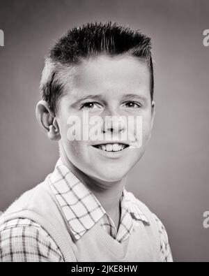 1950S PORTRAIT D'UN GARÇON DE 9 ANS AVEC UNE COUPE À LA MODE EN ÉQUIPE COIFFANTE EN REGARDANT L'APPAREIL PHOTO PORTANT UNE CHEMISE ET UN CHANDAIL GILET - J886 HAR001 HARS MAILLOT DE CORPS CONFIANCE B&W CONTACT VISUEL BONHEUR TÊTE ET ÉPAULES GAIE ET COIFFURE ÉQUIPE COUPÉE BEAU FIERTÉ SOURIRES JOYEUSE STYLE 9 CREWCUT CROISSANCE JEUNES PRÉ-ADOLESCENT PRÉ-ADOLESCENT GARÇON NOIR ET BLANC CAUCASIEN ETHNICITÉ HAR001 À L'ANCIENNE Banque D'Images