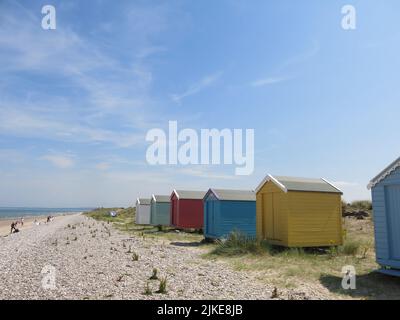 Une rangée de cabanes de plage colorées sur le rivage à Findhorn, l'un des joyaux cachés de la côte de ne Moray en Écosse. Banque D'Images