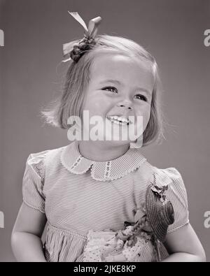 1940S PORTRAIT SOURIANT JOLIE BLONDE FILLE PORTANT UN NOEUD DANS LES CHEVEUX TENANT UNE POUPÉE - J9257 HAR001 HARS STUDIO SHOT MAISON VIE COPIE ESPACE EXPRESSIONS B&W JOLIE TÊTE ET ÉPAULES JOYEUSE LOISIRS SOURIRES CONCEPTUEL AGRÉABLE AGRÉABLE AGRÉABLE CHARMANT JEUNES ADORABLE ADORABLE NOIR ET BLANC CAUCASIEN ETHNICITÉ HAR001 OLD FASHION Banque D'Images