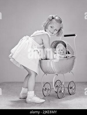 1940S FILLE BLONDE SOURIANTE VÊTUE DE ROBE BLANCHE RAMASSANT SA POUPÉE D'UN POUSSETTE JOUET PRAM TOUT EN REGARDANT PAR-DESSUS ELLE EPAULE - J9292 HAR001 HARS B&W MATERNEL BONHEUR GAI MODÈLES SOURIANTS SOURIRES FÉMININS IMAGINATION CONCEPTUELLE JOYEUSE RÔLE-JEU ÉLÉGANT BÉBÉ BUGGY COMPORTEMENT CROISSANCE DES SEXES JUVÉNILES STÉRÉOTYPÉ LA PORTAGE DE BÉBÉ NOIR ET BLANC RACE BLANCHE HAR001 ANCIENNE Banque D'Images