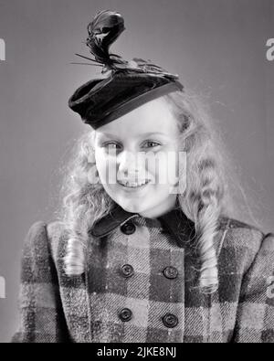 1940S JEUNE FILLE BLONDE SOURIANTE PORTANT UN CHAPEAU SILLY AVEC DES CHEVEUX LONGS EN PLUMES DANS DES BOUCLES DE BALONEY UN MANTEAU CROISÉ EN LAINE - J9203 HAR001 HARS STUDIO SHOT SAIN ESPACE DE COPIE DEMI-LONGUEUR PLAID FRECKLES CONFIANCE B&W OEIL CONTACT BONHEUR GAI STYLES BOUCLES FIERTÉ SOURIRES JOYEUSE STYLE WOOLEN BALONEY VÊTEMENTS DE CROISSANCE JEUNES AVANT L'ADOLESCENCE FILLE NOIR ET BLANC RACE BLANCHE HAR001 ANS À LA MODE Banque D'Images