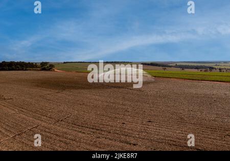 Irrigation dans le champ de canne à sucre nouvellement planté par un jour ensoleillé au Brésil - vue de drone Banque D'Images