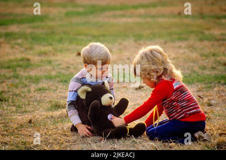 1980S BLONDE GARÇON ET FILLE JOUANT DOCTEUR AVEC OURS EN PELUCHE DANS LA COUR FILLE À L'ÉCOUTE DU COEUR DE L'OURS AVEC JOUET STÉTHOSCOPE - KJ10542 NET002 HARS VIEILLE MODE SOEUR 1 TEDDY JUVÉNILE COUR BLONDE INFIRMIÈRE MYSTÈRE JOIE STYLE DE VIE ÉCOUTER FEMMES FRÈRES RURAUX MALADIE BOURRÉE MAISON VIE COPIE ESPACE AMITIÉ PLEINE LONGUEUR DEMI-LONGUEUR PHYSIQUE PERSONNES S'OCCUPANT HOMMES FRÈRES ET SŒURS STÉTHOSCOPE SOINS PROFESSION PRÉVENTION FOURNISSEURS DE SOINS DE HAUT NIVEAU DÉCOUVERTE PRATICIENS GUÉRISON DES BIENS DIAGNOSTIC EXCITATION MÉDECINS TROUBLES DES SOINS DE SANTÉ PROFESSIONS FRÈRE TRAITEMENT GUÉRISSEUR CONCEPTUEL Banque D'Images