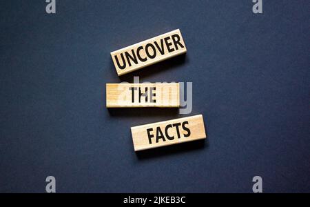 Uncover the facts symbol. Concept words Uncover the facts on wooden blocks on a beautiful black table black background. Business and uncover the facts Banque D'Images