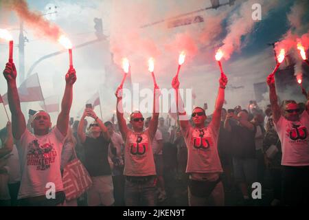 Varsovie, Pologne. 01st août 2022. Les participants tiennent des fusées éclairantes pour commémorer le 78th anniversaire du soulèvement de Varsovie. Des milliers de personnes ont participé à une marche organisée par les organisations nationalistes pour célébrer le 75th anniversaire du soulèvement de Varsovie. Le soulèvement de Varsovie (Powstanie Warszawskie) a été la plus grande opération militaire par tout mouvement de résistance en Europe contre les occupants allemands nazis pendant la Seconde Guerre mondiale Crédit : SOPA Images Limited/Alamy Live News Banque D'Images