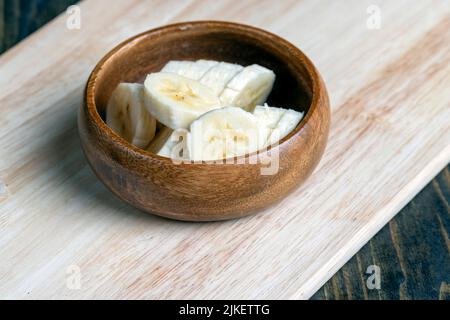 tranché de banane mûre sur une planche en bois, cuisant de la banane trantée en tranches Banque D'Images