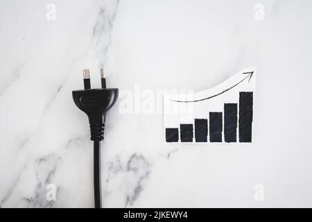 les coûts de l'électricité monter, image conceptuelle avec plug nxt à stats graphique montrant les prix monter Banque D'Images