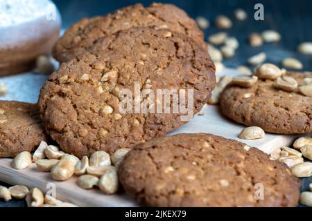 biscuits aux flocons d'avoine avec arachides sur une table en bois noir, biscuits faits maison aux flocons d'avoine avec noix d'arachide Banque D'Images