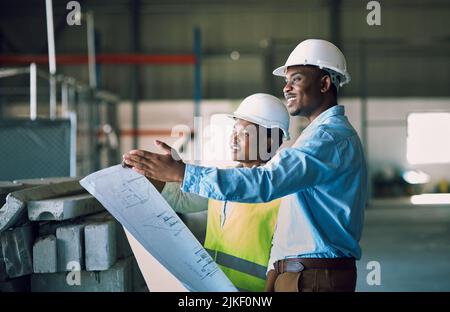 Passer des inspections de sécurité à chaque fois. Deux constructeurs ayant une réunion sur un chantier de construction. Banque D'Images