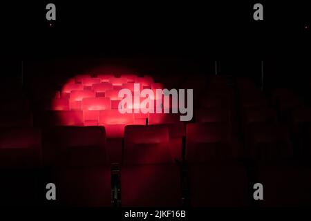 Sièges de théâtre rouge Emply avec cercle de spot. Banque D'Images
