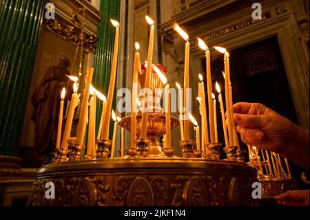 l'éclairage d'une bougie dans une église. église de bougie. Une rangée de bougies de cire allumées dans l'église orthodoxe chrétienne sur un fond sombre flou. Note brûlante Banque D'Images