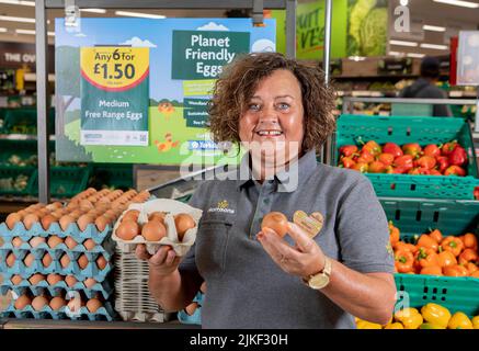 EDITORIAL À TITRE de championne de la communauté, Allison Audsley détient un « Planet friendly Egg » dans une succursale de Morrisons près de Hull, alors que le supermarché devient le premier à lancer sa propre gamme d'oeufs neutres en carbone. Date de publication : mardi 2 août 2022. Dans les magasins d'aujourd'hui, les œufs proviennent de fermes où les poules sont nourries d'insectes sans soja, qui sont à leur tour alimentés par les déchets alimentaires de ses sites de boulangerie, de fruits et de légumes, créant ainsi un système d'alimentation « de déchets circulaires ». Les œufs, qui ont été confirmés comme neutres en carbone par un rapport de l'Université de Cambridge, font partie de l'engagement de Morrisons à être directement fournis par Banque D'Images