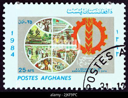 AFGHANISTAN - VERS 1985 : un timbre imprimé en Afghanistan pour l'anniversaire du Parti démocratique populaire de 20th montre Globe and Emblem. Banque D'Images