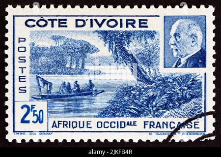 CÔTE D'IVOIRE - VERS 1941 : un timbre imprimé en Côte d'Ivoire montre la lagune d'Ebrie et le maréchal Petain, vers 1941. Banque D'Images