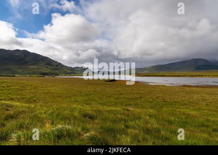 Un paysage de tourbières et de lacs dans le parc national de Ballycroy avec la chaîne de montagnes Nephin à l'arrière Banque D'Images