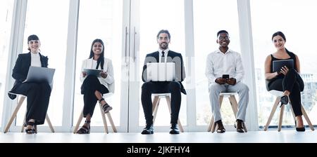 Jeu d'attente. Groupe d'hommes d'affaires utilisant des appareils numériques dans un bureau. Banque D'Images