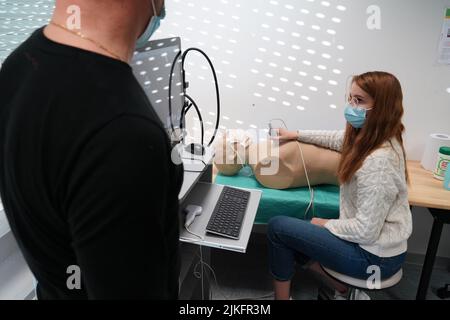 Les élèves et leur enseignant lors d'un atelier de simulation d'échographie sur un mannequin robot. Banque D'Images