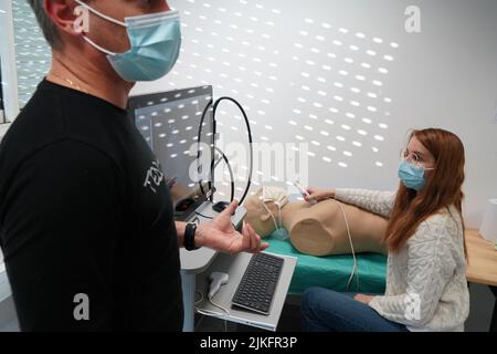 Les élèves et leur enseignant lors d'un atelier de simulation d'échographie sur un mannequin robot. Banque D'Images