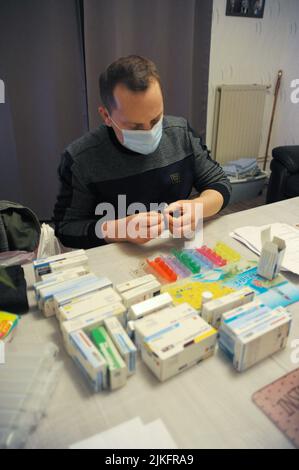 Une infirmière privée prépare une boîte à pilules au domicile d'un patient. Banque D'Images