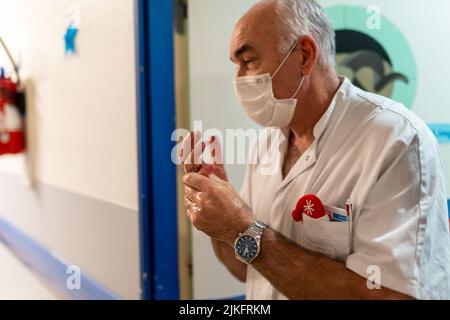 Personnel infirmier pendant une éclosion de bronchiolite à l'hôpital pédiatrique de jour. Banque D'Images