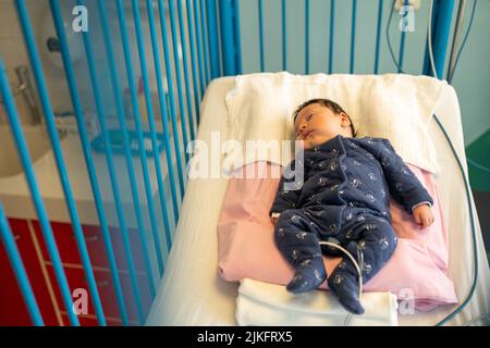 Mère et fils atteints de bronchiolite avec une infirmière en pépinière dans un service pédiatrique de l'hôpital. Banque D'Images