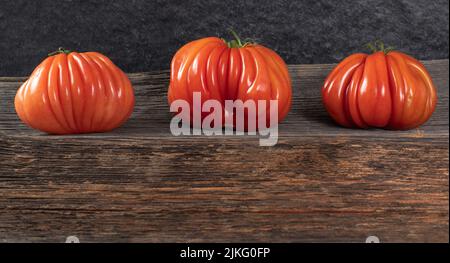 Un groupe de grosses tomates Costoluto sur fond de bois, espace pour le texte Banque D'Images