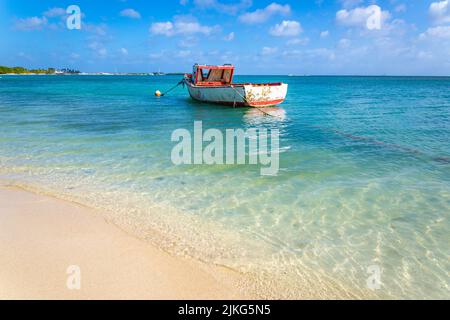 Plage idyllique avec bateau de pêcheurs rustique en bois à Aruba, Antilles néerlandaises Banque D'Images