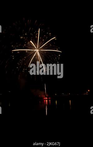 Des traînées de lumière vives entourées de taches plus claires dans les feux d'artifice Banque D'Images