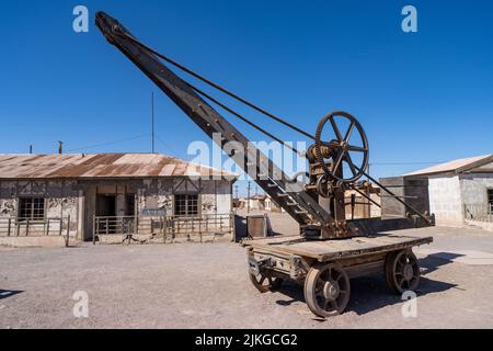 Exposition en plein air d'une ancienne grue de levage sur les voies ferrées utilisées dans les travaux de salpeter à Humberstone, au Chili. Banque D'Images