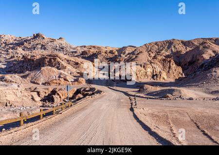 La route de terre à travers les formations de siltstone dans la Vallée de la Lune ou Valle de Luna près de San Pedro de Atacama, Chili. Banque D'Images