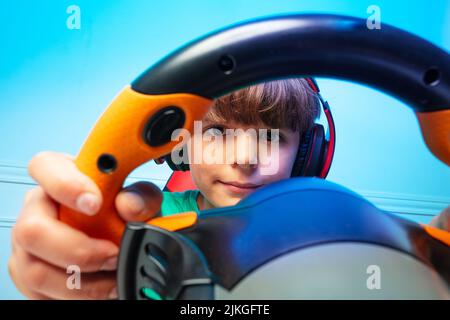Portrait rapproché par le volant de la console d'un gamer garçon Banque D'Images