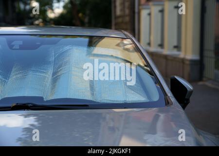 Surface réfléchissante protectrice sous le pare-brise de la voiture par temps chaud, chauffée par les rayons du soleil à l'intérieur de la voiture Banque D'Images