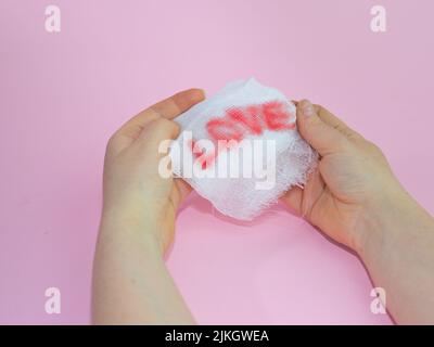 A man's hands holding a white gauze with a word 'LOVE' Stock Photo