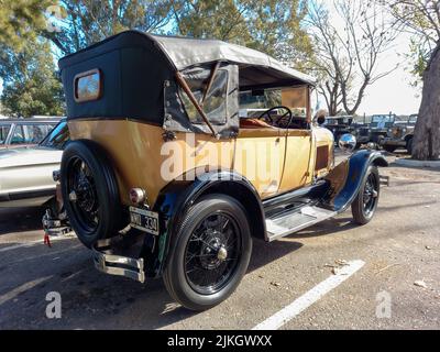 Vieux jaune crème Ford modèle A Phaeton Fordor 1928 dans un parc. Vue arrière. Nature, vert, arbres. Salon de la voiture classique. CopySpace Banque D'Images