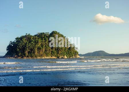 petite île couverte de végétation tropicale primaire sur la mer, au coucher du soleil Banque D'Images