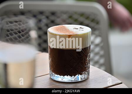 The Irish coffee in glass on wooden table at restaurant , close-up Stock Photo