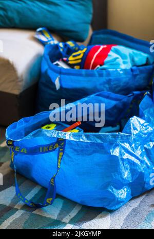 Un gros plan de deux sacs en plastique bleu Ikea sur un tapis de sol. Banque D'Images