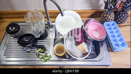 A pile of unwashed dirty dishes in the sink Stock Photo