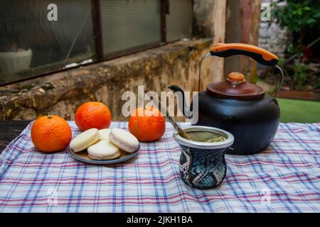 A teapot, mate tea, cookies and fruits on the table Stock Photo