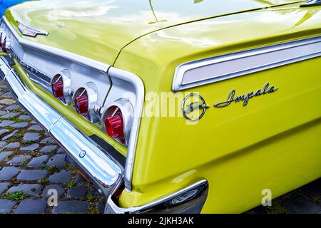 Vue rapprochée de l'arrière de l'Impala de Chevrolet, voiture américaine classique peinte en jaune à Hanovre, en Allemagne, en 23 juillet 2022 Banque D'Images