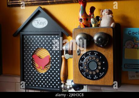 A close-up shot of a vintage phone and other decorations on the wall Stock Photo