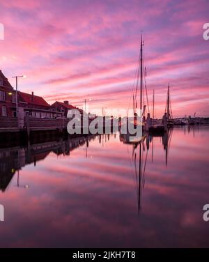 a beautiful view of purple sunset over the river with sailboats Banque D'Images