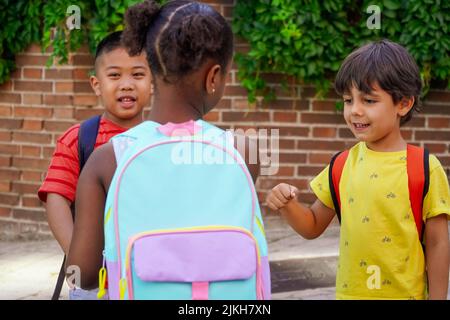 enfants multiethniques avec emballages à l'entrée de l'école. Concept de retour à l'école. Groupe multiethnique d'enfants Banque D'Images