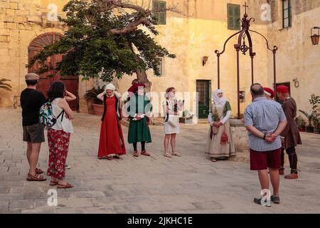 Une dame vêtue d'un costume d'époque comme un herboriste explique à un public herbes et leurs utilisations dans une reconstitution de la vie de 15th siècle à Mdina, Malte, Banque D'Images
