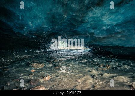 Incroyable grotte de glace bleue sculptée dans le glacier de Vallelunga traversé par un ruisseau Banque D'Images